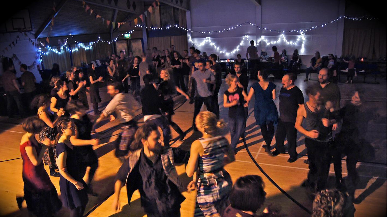 People dancing at a ceilidh with lights and decor